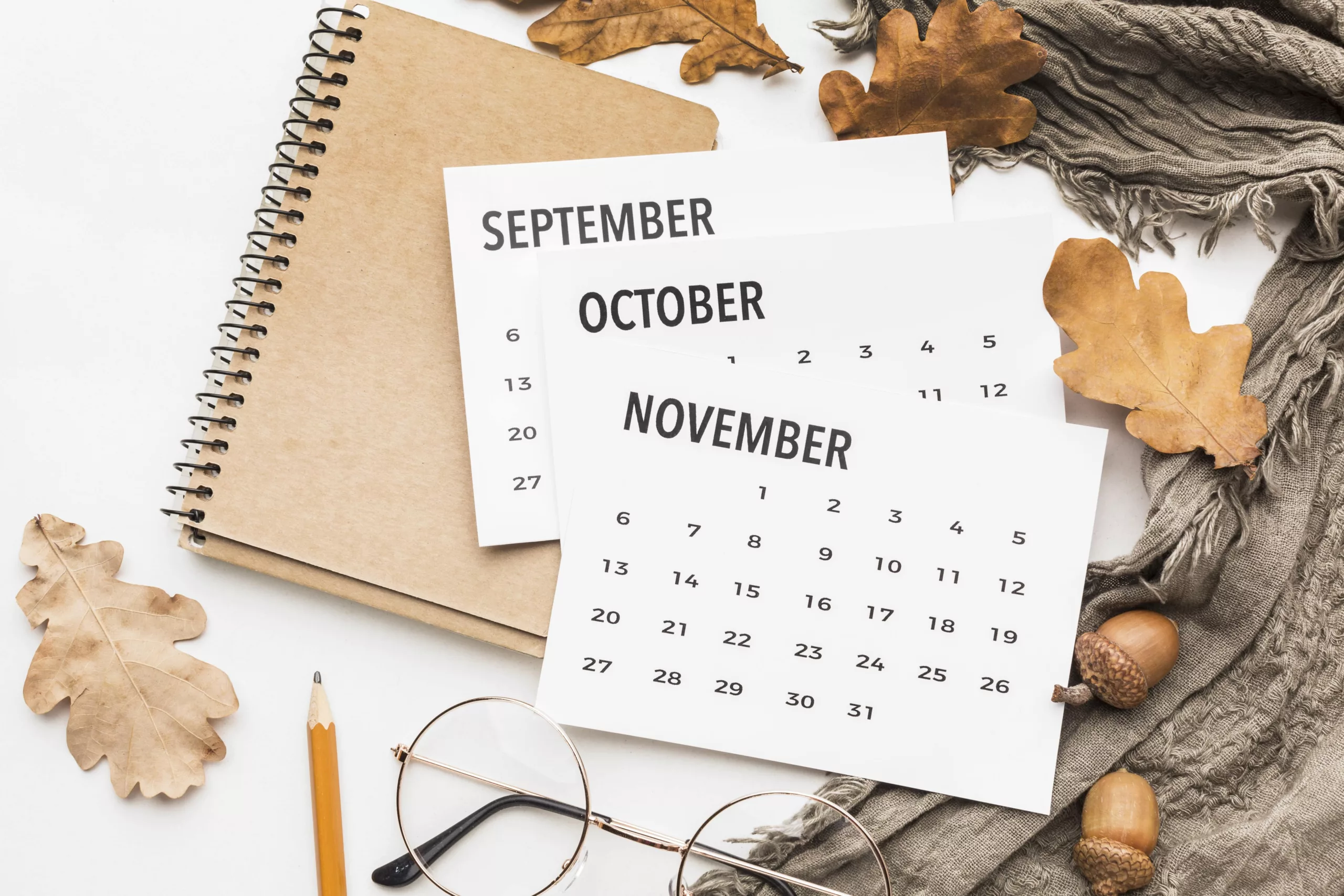 top-view-calendar-with-glasses-autumn-leaves-min